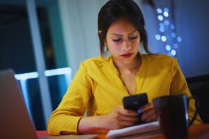 Ragazza con espressione assorta scrive su smartphone