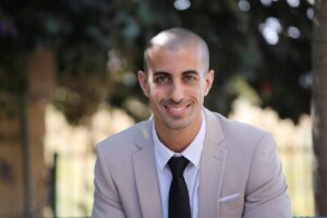 uomo seduto che guarda avanti e sorride